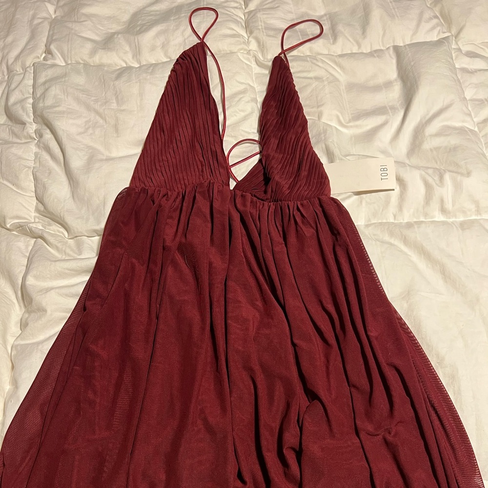TOBI size small NWT mini dress with deep V neckline and flowy material.